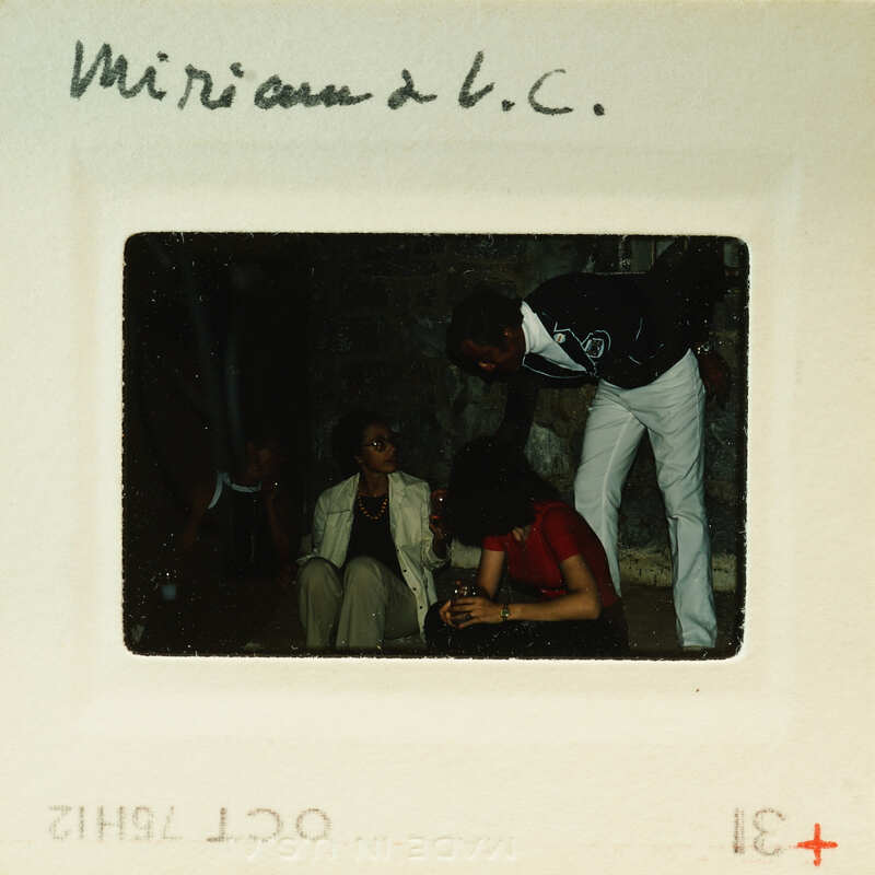 A vintage photograph of a group of people, with handwritten notes on the border.