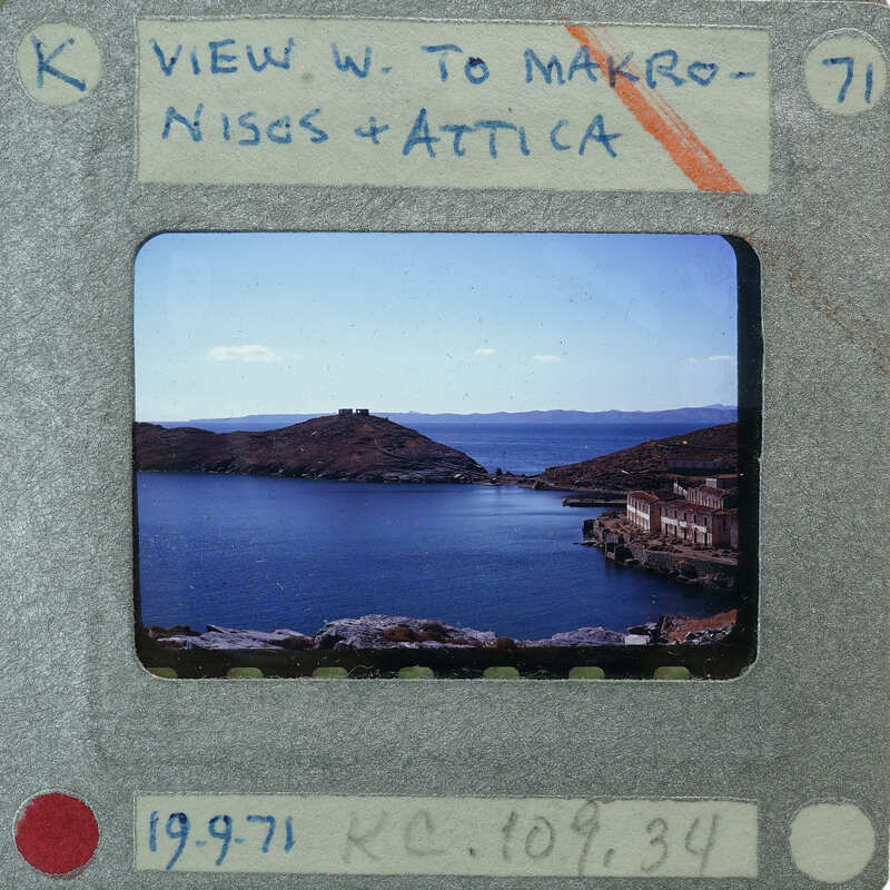 A vintage film strip with a photograph of a scenic coastal landscape.