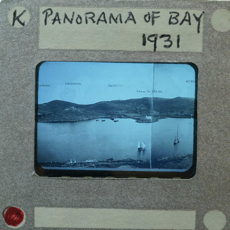 A vintage photograph of a bay with boats and hills, labeled "PANORAMA OF BAY 1931" on its border.