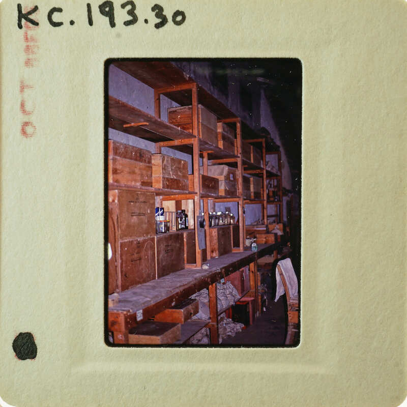 Picture of a cluttered room with shelves, taken from an old film strip.