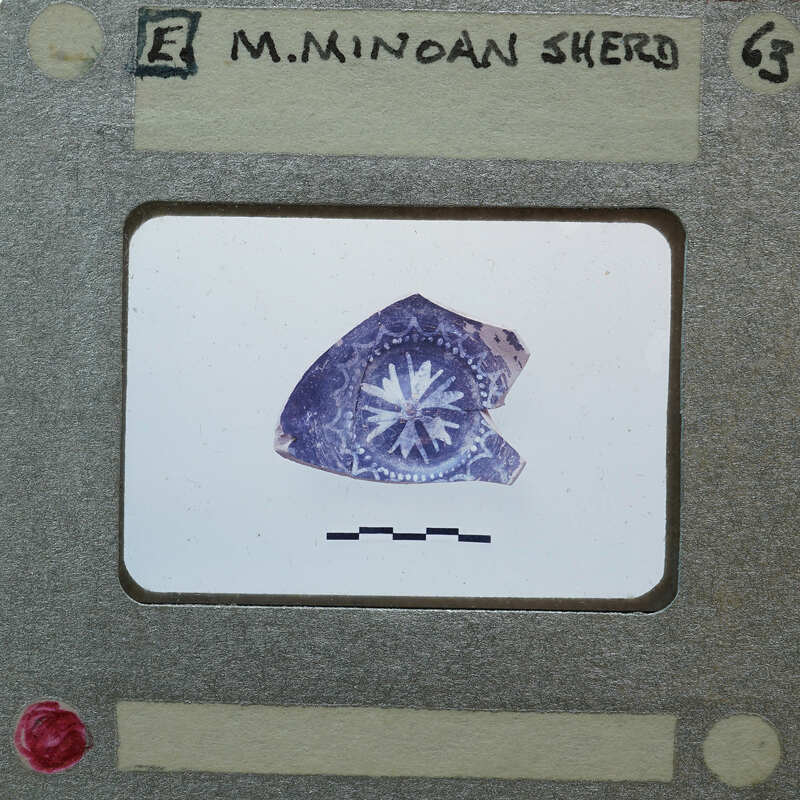 A close-up image of a small, worn object with a star-like design on it.