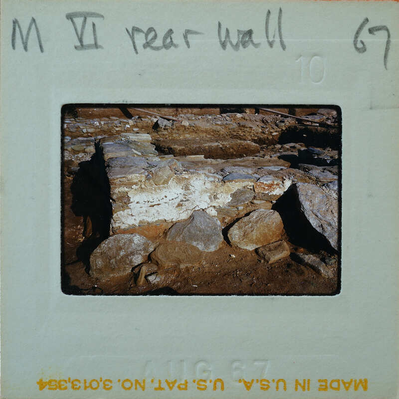 A photo of a rock wall with handwritten notes on the front and back.