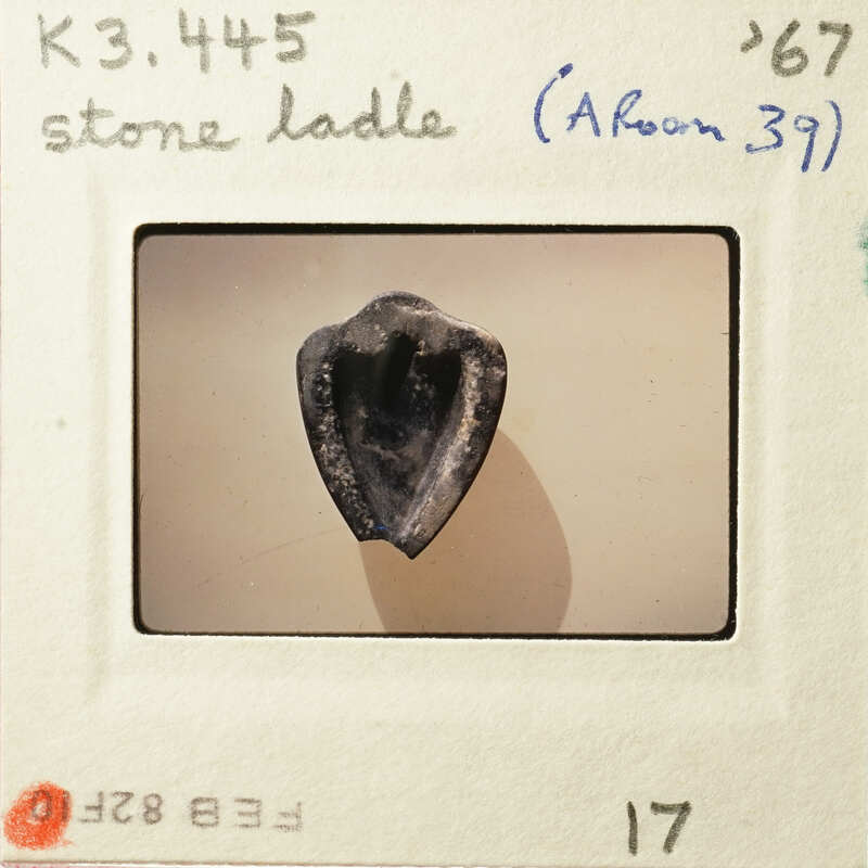 A photograph of an ancient stone tool, specifically a flint blade with a heart-shaped cross-section.