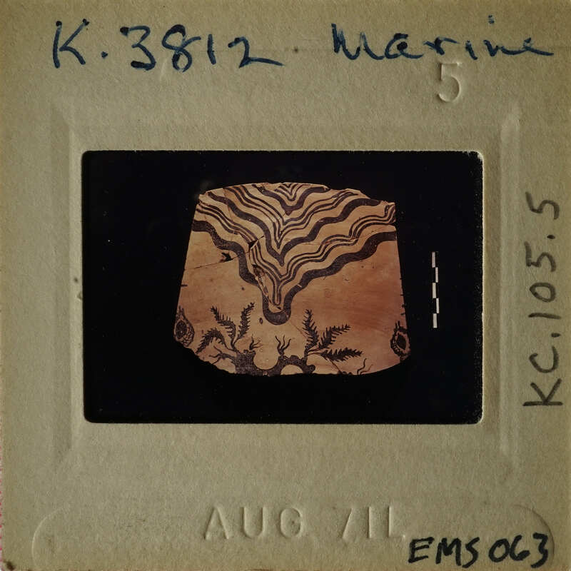 A photograph of an ancient artifact with intricate designs, possibly a pottery shard, on display.