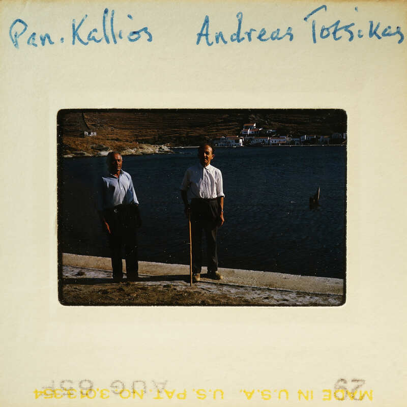 Two men standing on a dock near the water, with a vintage film strip border around the image.