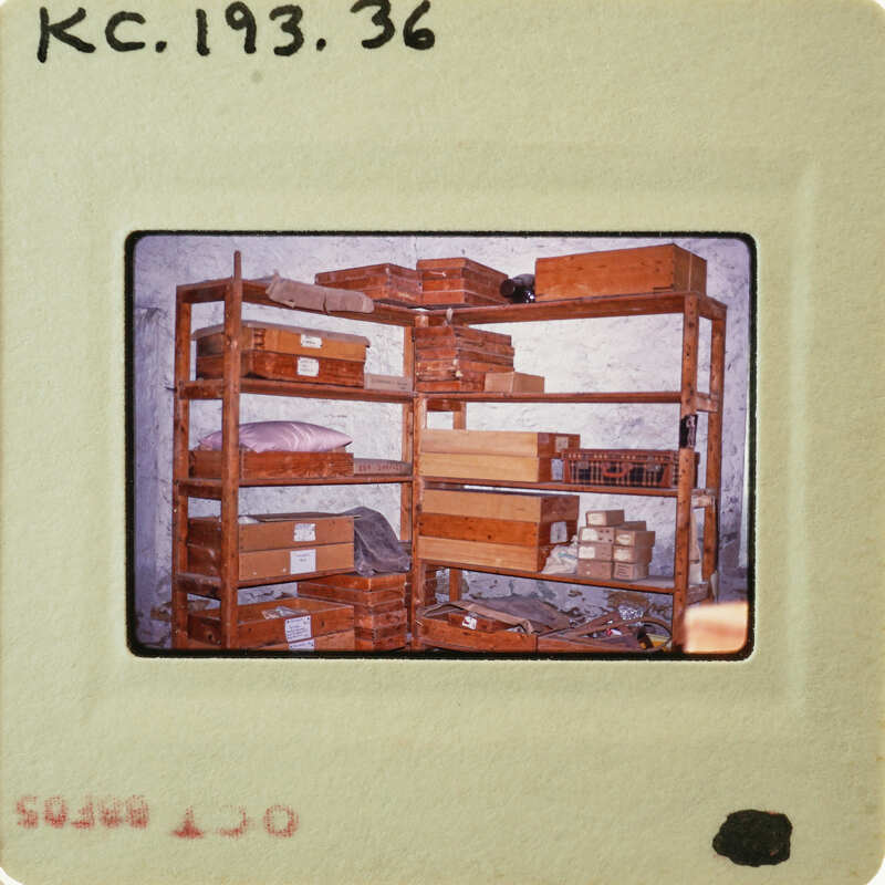 Photo of a shelf with boxes and items, possibly from an old photo album or scrapbook.