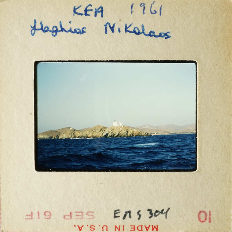 A photograph of an island with a lighthouse on a blue ocean background.