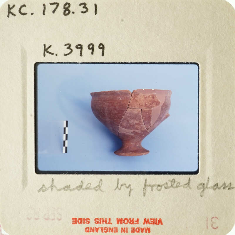 Broken clay pot with visible cracks and missing pieces, photographed on white background.