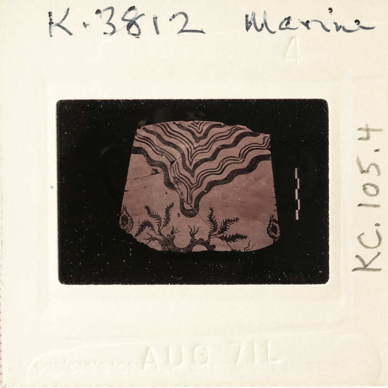 A black and white photograph of a clay artifact with intricate designs.