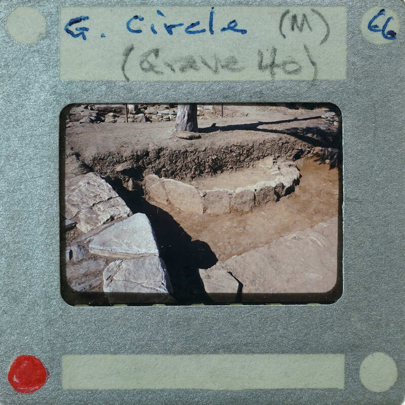 An old photo of a stone structure with handwritten notes on the border.
