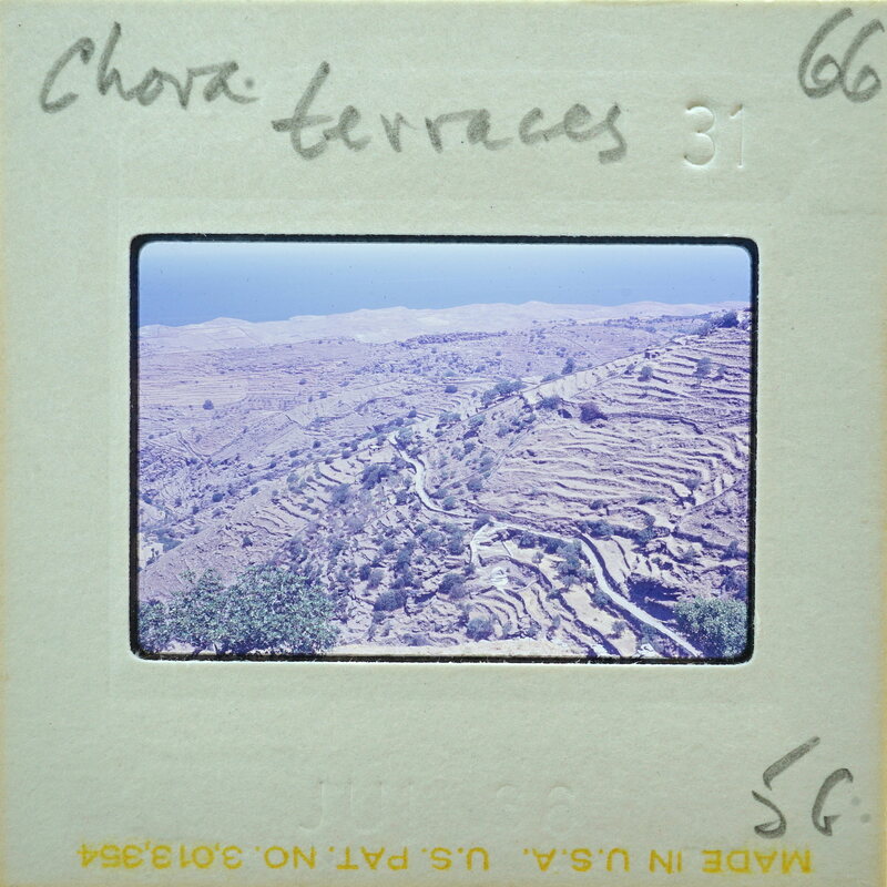 A vintage film strip with a photo of rugged terrain and mountains.