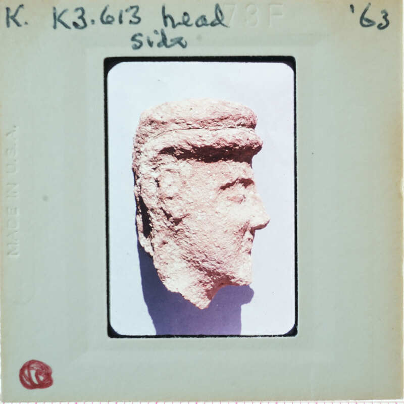 Terracotta face of figurine from side.