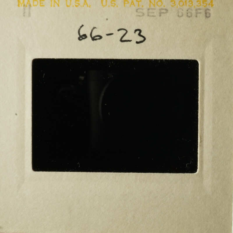 A vintage photo with a handwritten note on it, placed in a lightbox.