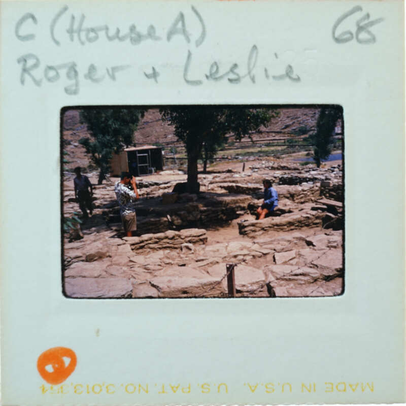 A vintage photo of a man and woman standing near an outdoor stone structure with trees in the background, labeled "House A" and dated "68."