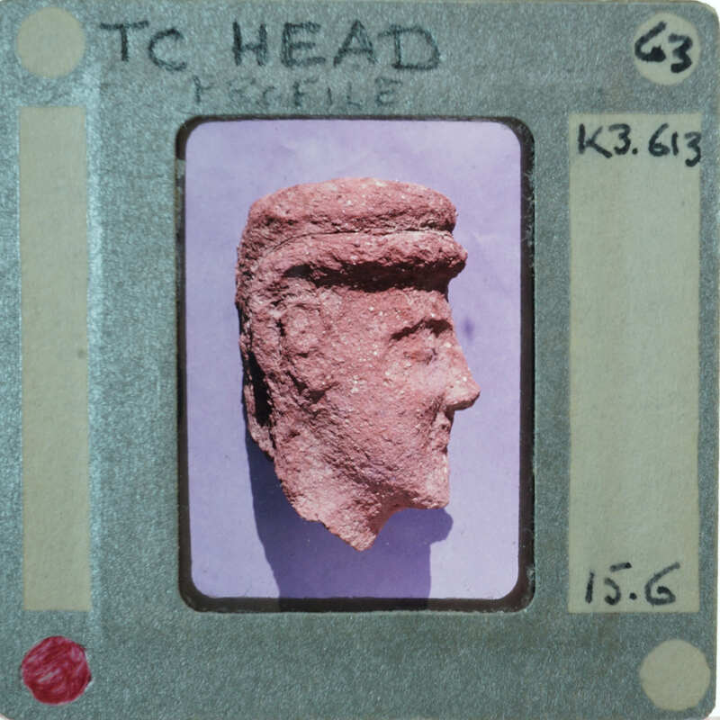 Terracotta face of figurine from side.