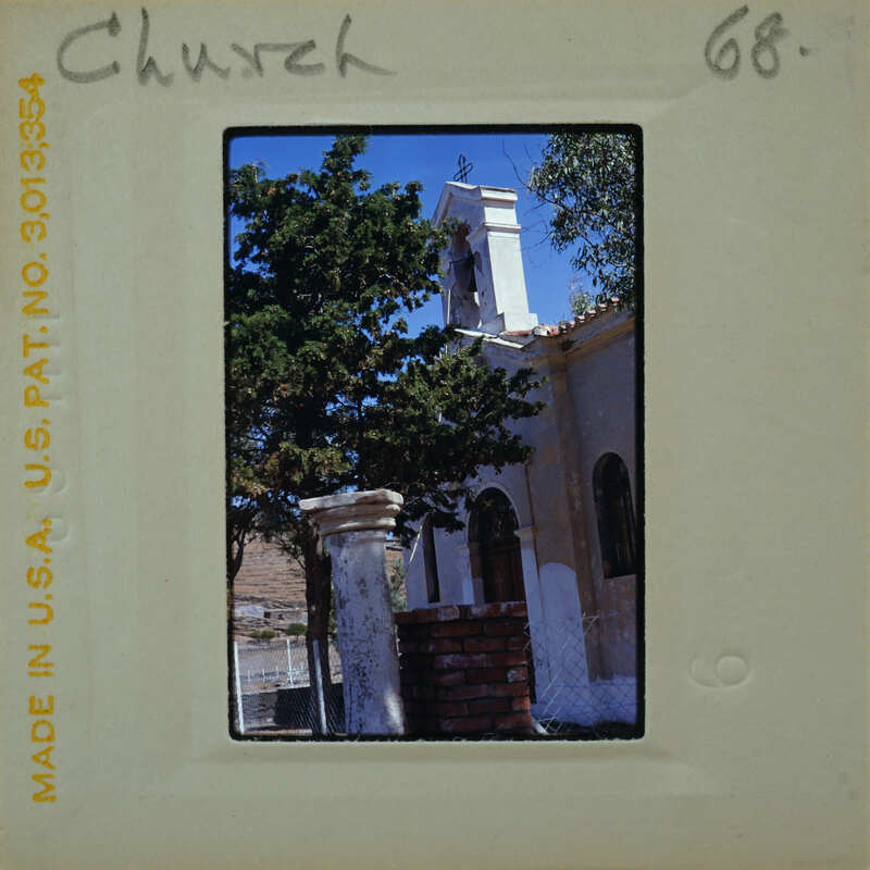 An old church with a bell tower and trees.