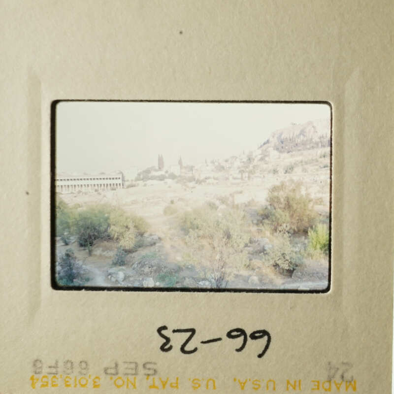 This is an old photograph depicting a scenic landscape with a mountain and buildings, possibly taken during a trip.