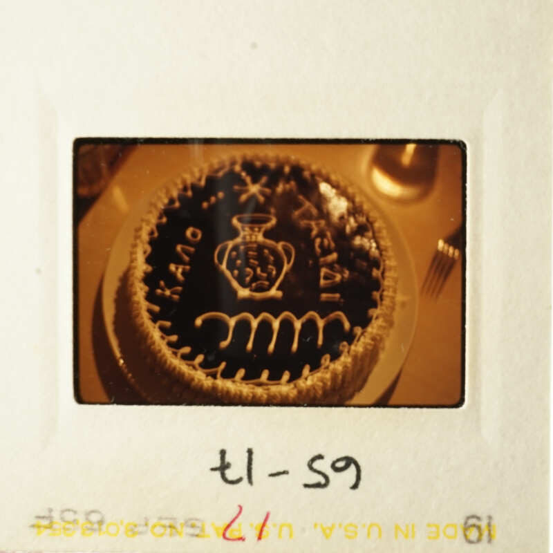 Cake with frosting and writing on it, placed on a table.