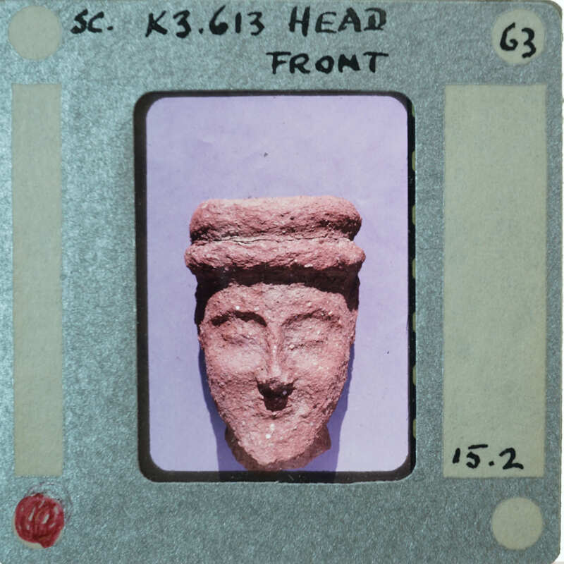 Terracotta face of figurine from front.