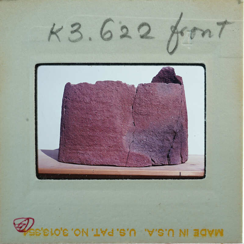 Broken base of terracotta figurine skirt from front.