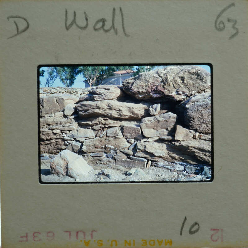 A photograph of a rock wall with a label on the bottom left corner.