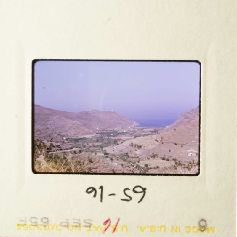 A scenic view of a mountainous landscape with a clear sky and a small town visible in the distance.