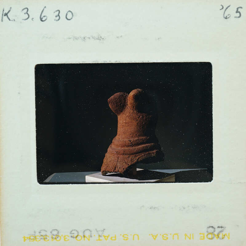 A photograph of a small, ancient-looking figurine on display.