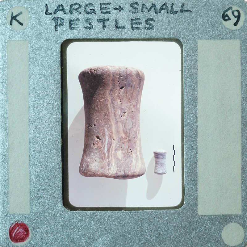 One large and one small cylindrical stone objects, identified as pestles.