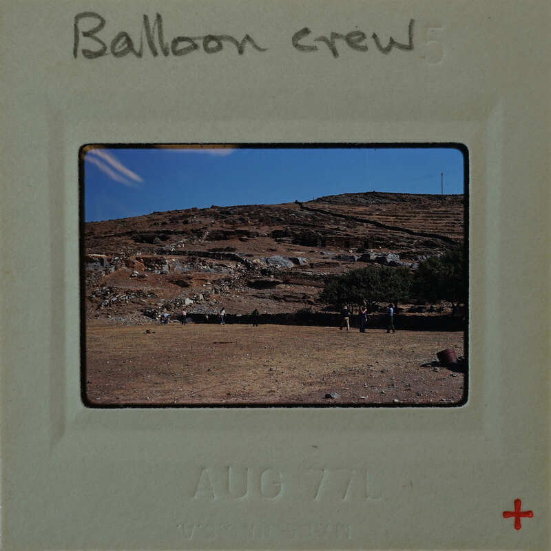 A balloon crew with a mountainous landscape in the background.