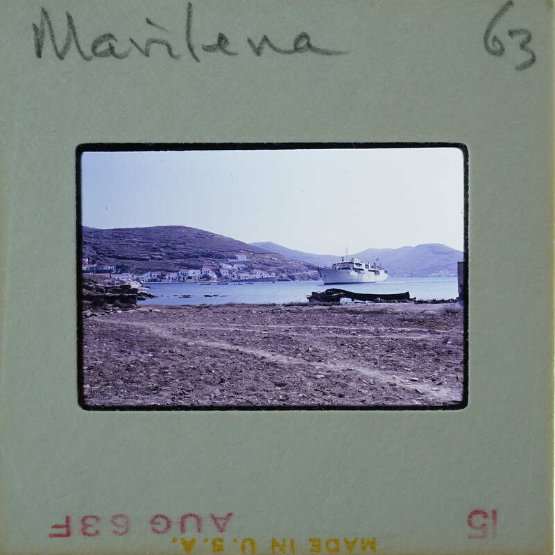 Picture of a beach with mountains and boats, labeled "MARLENA" on a film strip.