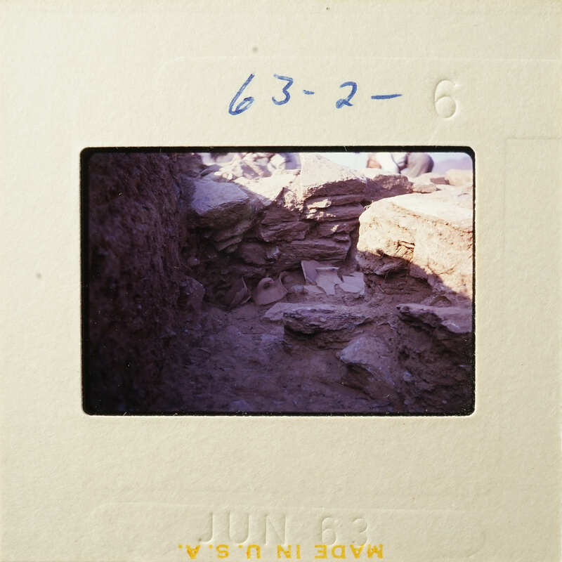 A photograph showing an archaeological site with excavated ruins and stones.