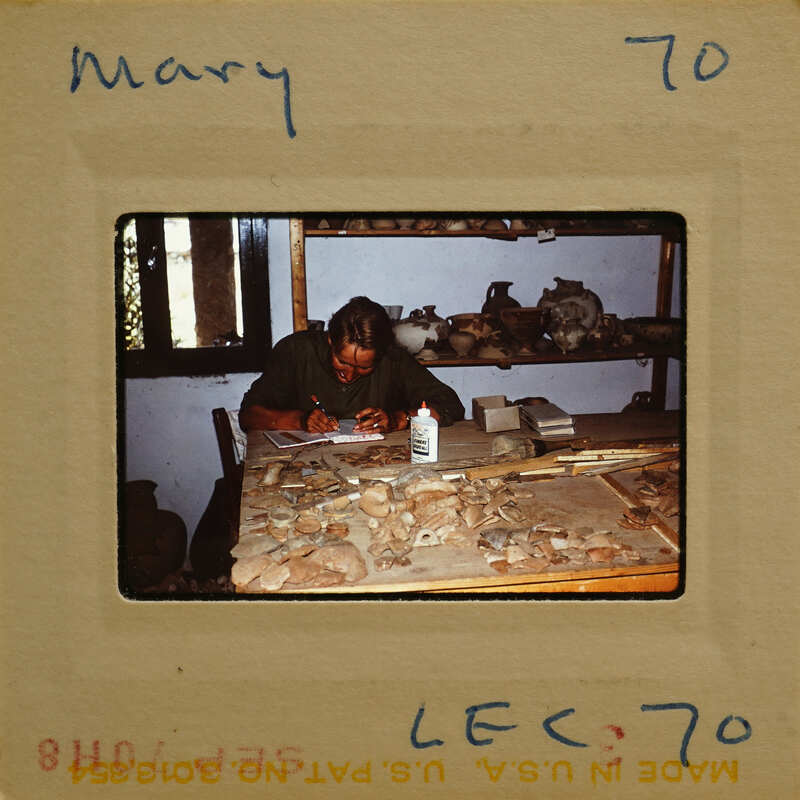 A person working on a project with various materials and tools around them.