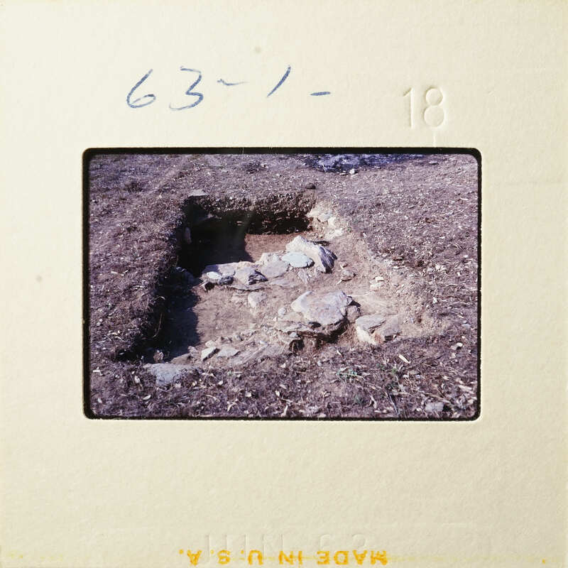 An excavated archaeological site with visible human remains and dirt.