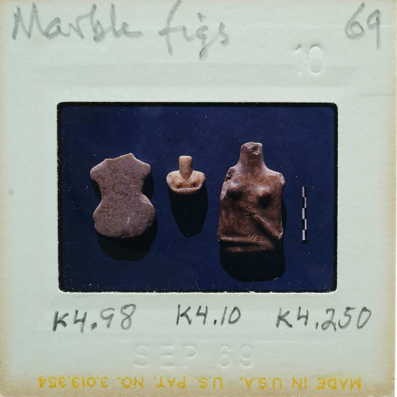 An old photograph with three marble figurines on a blue surface.