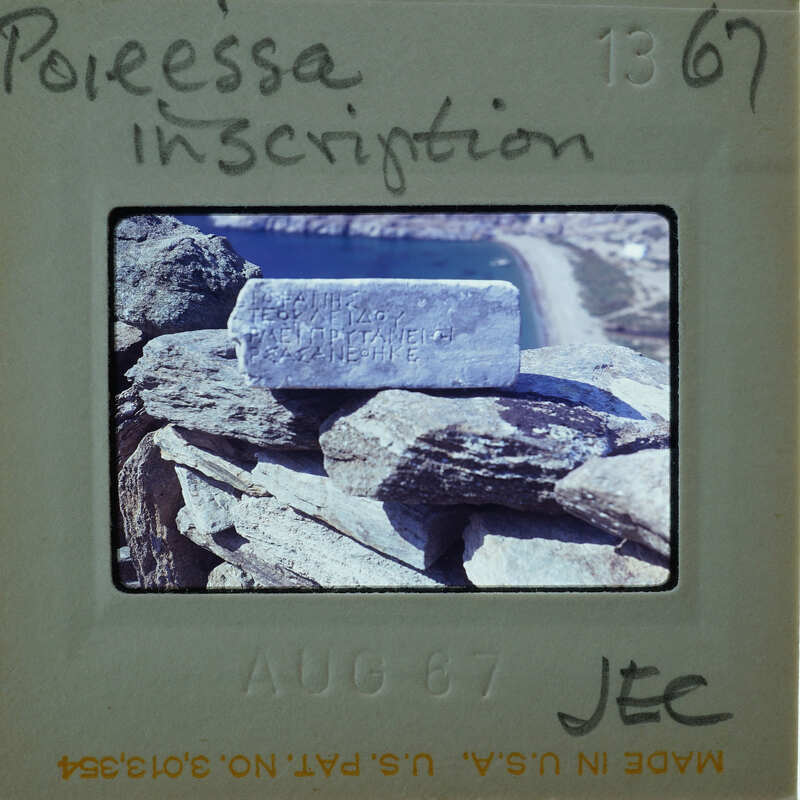 A photograph of a stone structure with an inscription on it, displayed on a film strip card.