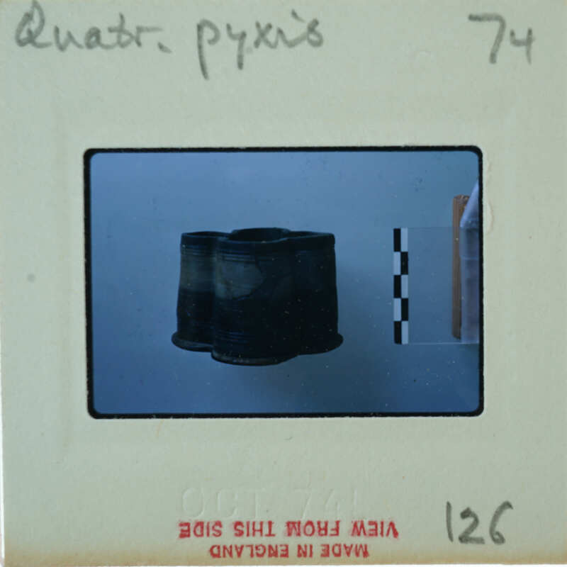 A vintage film strip with a single frame showing an object, possibly a hat or helmet.
