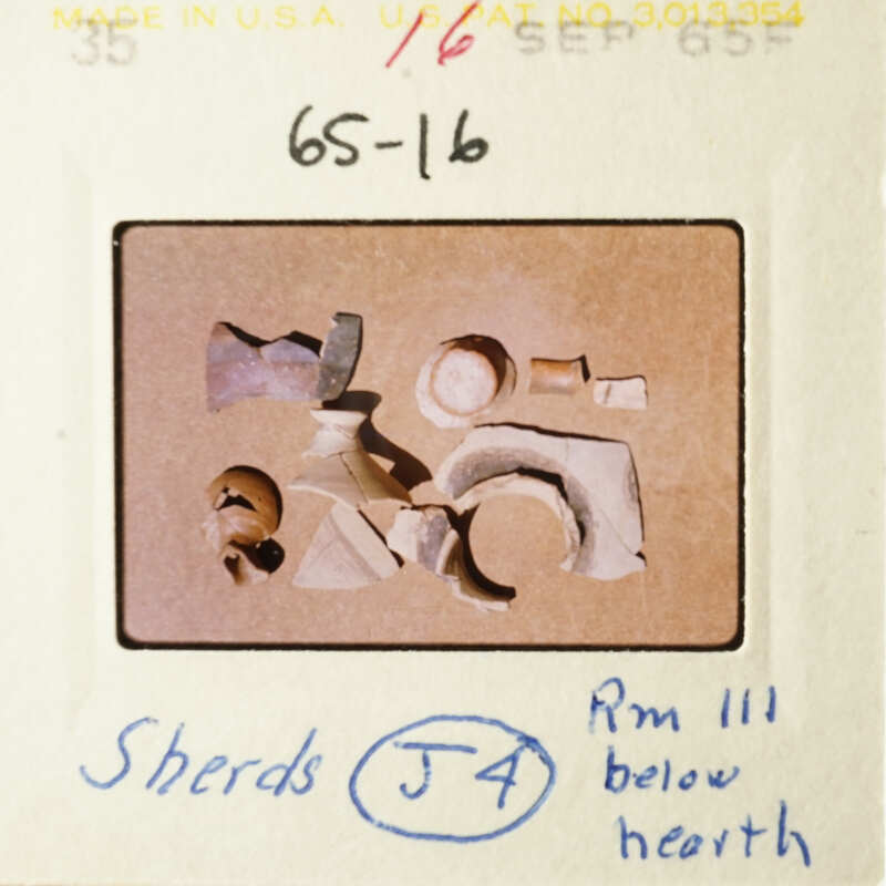 A collection of broken pottery pieces on a table, with some items placed atop others.