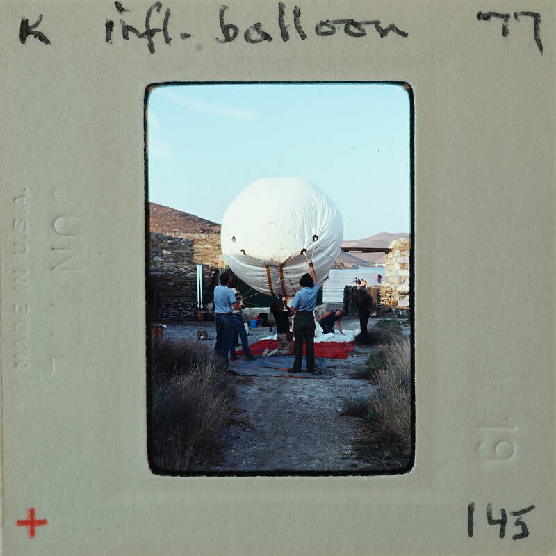 A vintage photograph of people preparing a large white balloon.