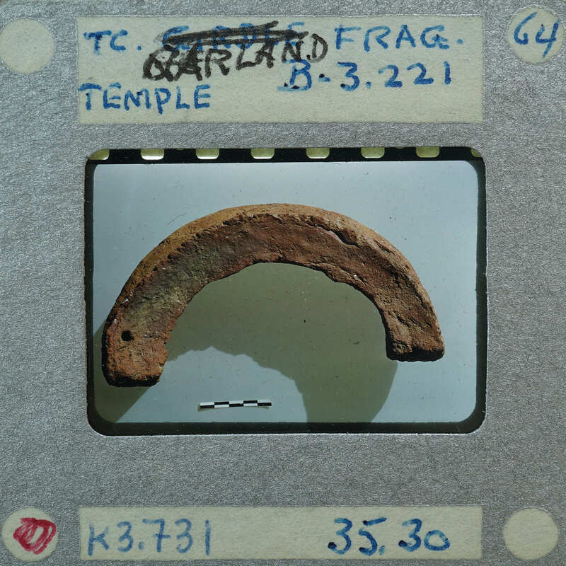 A photograph of a rusted metal object with an arrow pointing to it.