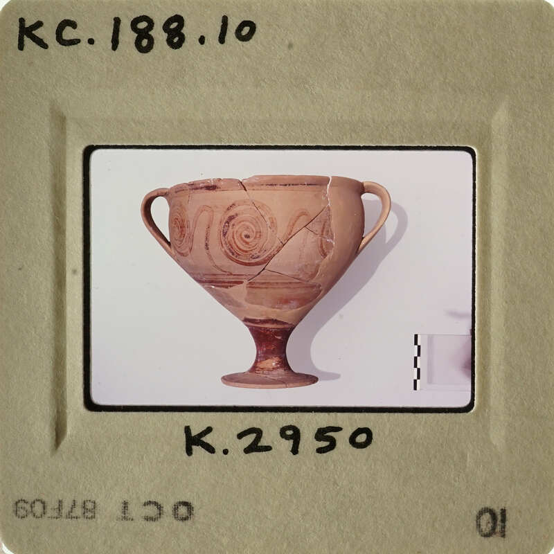 Ancient Greek vase with intricate designs, displayed on a white surface.