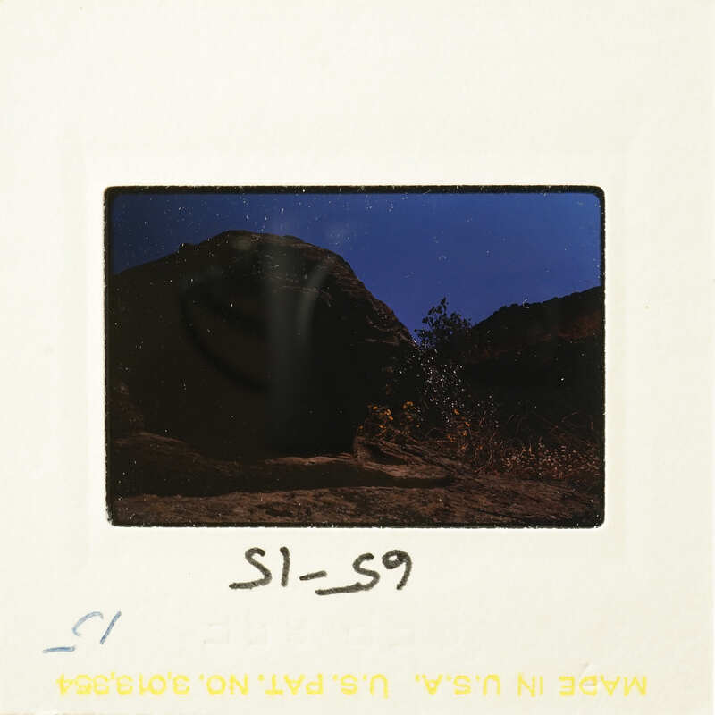 Mountains and sky in photograph with handwritten number "SL-59" on bottom right corner.