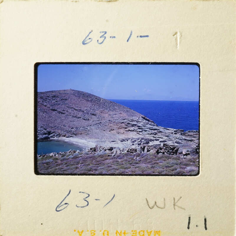 A photograph depicting a coastal landscape with a clear blue sky and water, possibly taken from an airplane window.