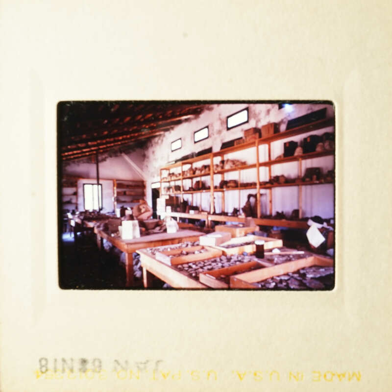 Photo: A vintage photograph of an interior space with shelves and items, possibly a shop or storage area.