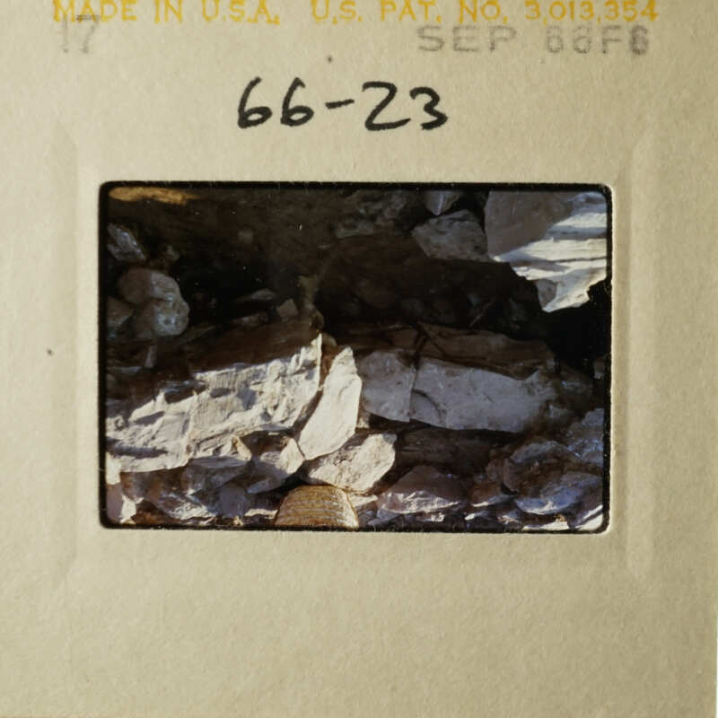 This is an image of a rocky landscape, possibly a river bank or mountainside, with a focus on the texture and color variations of the rocks.