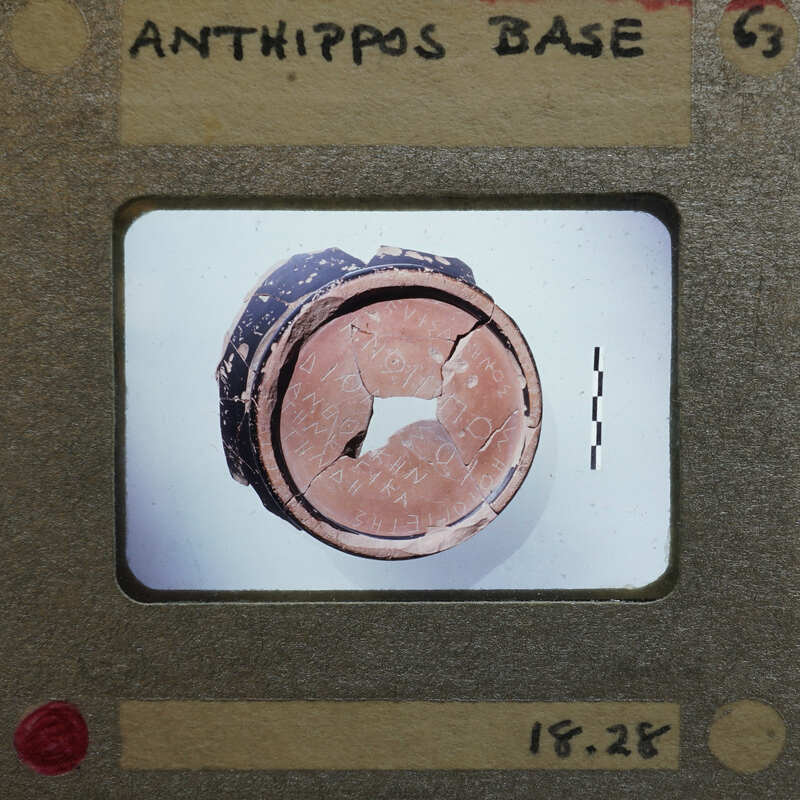 A worn-out, circular object with a hole in the center on a white background.