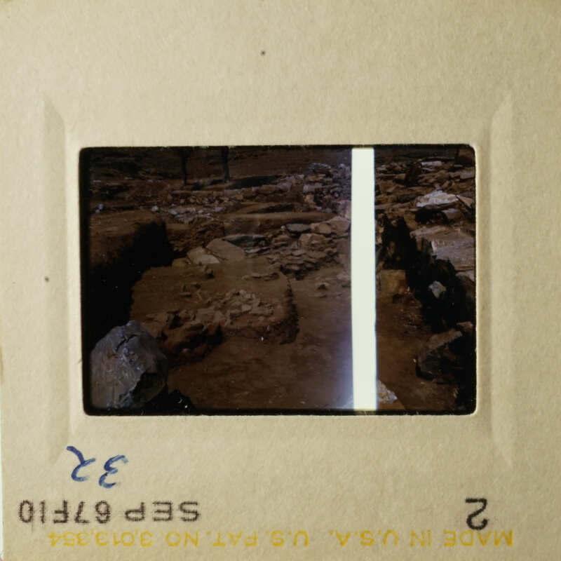 The image shows two 35mm film strips with scenes from an archaeological site, featuring ancient ruins and rock formations.