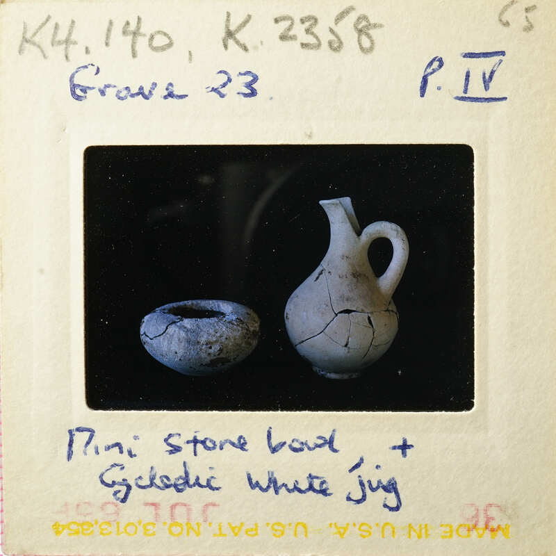 Old white jug with handle and spout on black background.