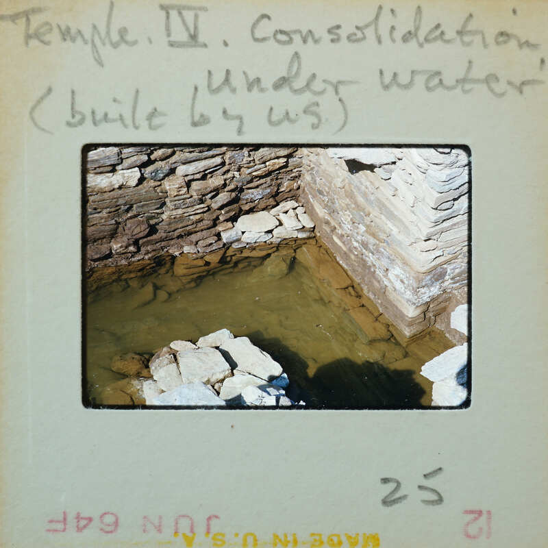 Detail of interior corner of tall stone wall with base under water.