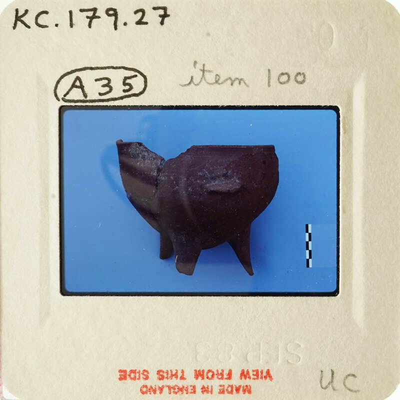 Small clay figurine resembling an animal on a blue background, with a label indicating "Item 100" and other details.