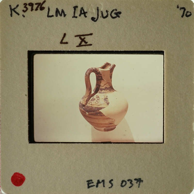 Ancient Greek vase on display with a focus on its handle and neck.